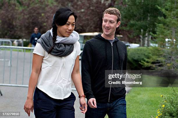 Mark Zuckerberg, chief executive officer and founder of Facebook Inc., walks with his wife Priscilla Chan while arriving for a morning session during...