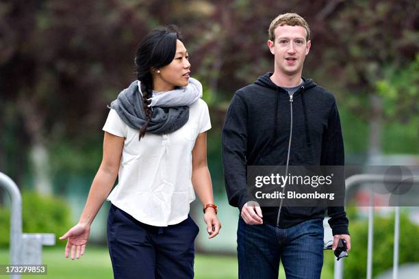 Mark Zuckerberg, chief executive officer and founder of Facebook Inc., walks with his wife Priscilla Chan while arriving for a morning session during...