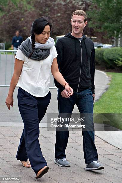 Mark Zuckerberg, chief executive officer and founder of Facebook Inc., walks with his wife Priscilla Chan while arriving for a morning session during...