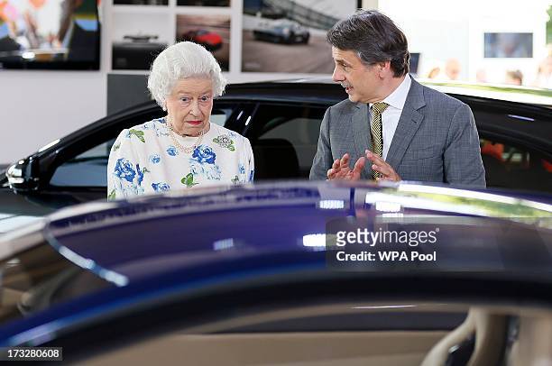 Britain's Queen Elizabeth looks at a Jaguar motor car on the first day of the Coronation Festival in the grounds of Buckingham Palace on July 11,...