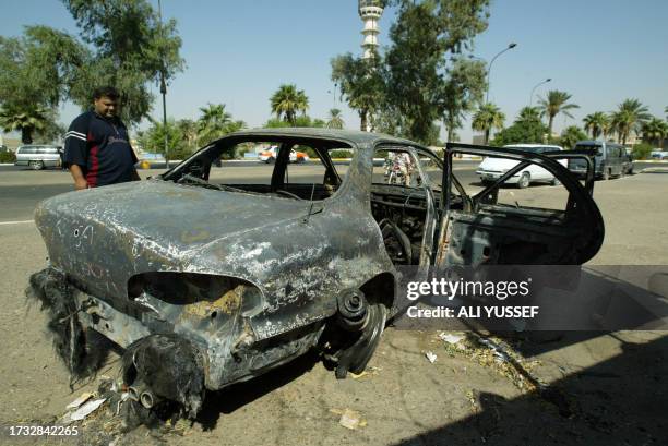 An Iraqi looks 24 September 2007, at a burnt car on the site where Blackwater guards who were escorting US embassy officials opened fire in the...