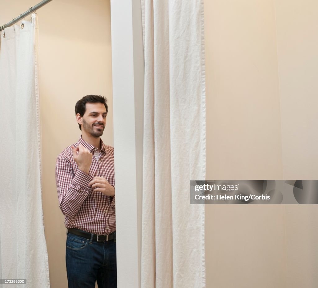 Man trying shirt in fitting room