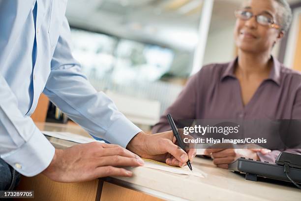 customer signing bank receipt - paper stock certificate stock pictures, royalty-free photos & images