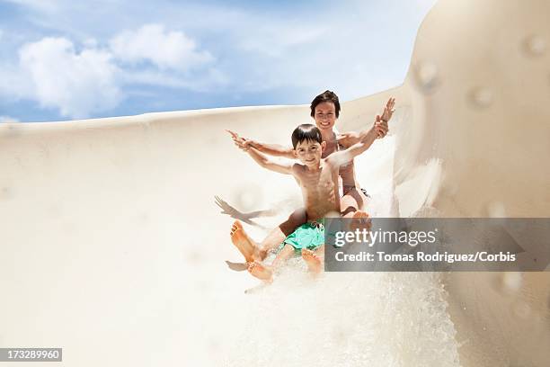mother with son (6-7) on water slide - water slide stock pictures, royalty-free photos & images