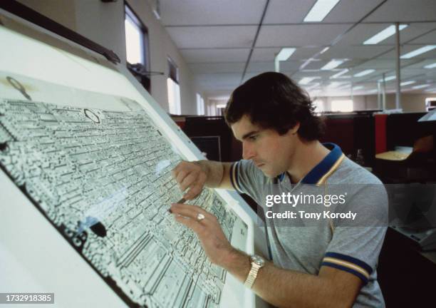 Technicien regardant un plan du système informatique dans l’usine Apple.