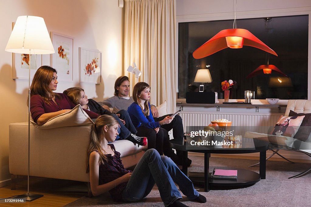 Family watching television together in living room