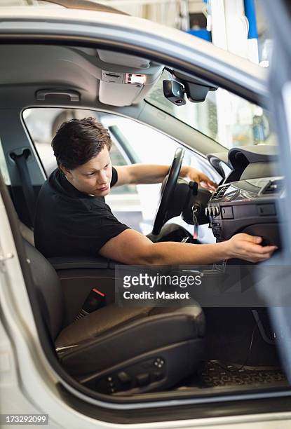 young male auto mechanic analyzing dashboard in car - glove box stock pictures, royalty-free photos & images