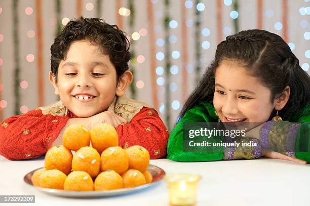 children looking at a plate of laddoo on diwali - laddu stock pictures, royalty-free photos & images