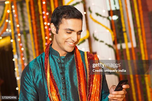 man text messaging on a mobile phone on diwali - kurta stock pictures, royalty-free photos & images