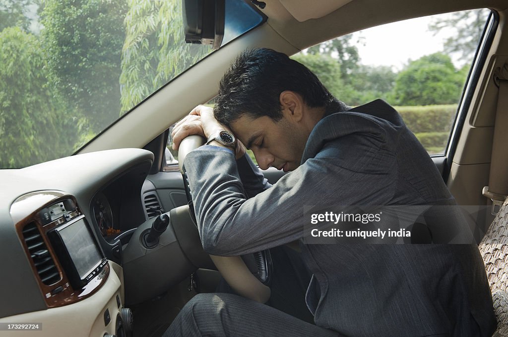 Businessman sitting in a car and looking upset