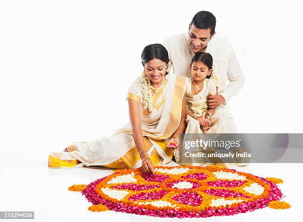 south indian family making a rangoli of flowers at onam - onam stock pictures, royalty-free photos & images