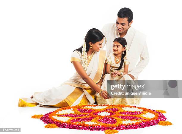 south indian family making a rangoli of flowers at onam - onam foto e immagini stock