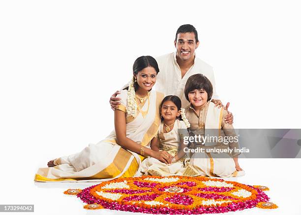 south indian family making a rangoli of flowers at onam - onam foto e immagini stock