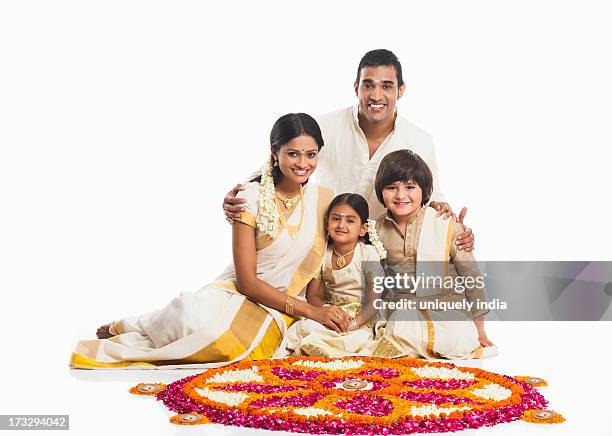 south indian family making a rangoli of flowers at onam - onam stock pictures, royalty-free photos & images