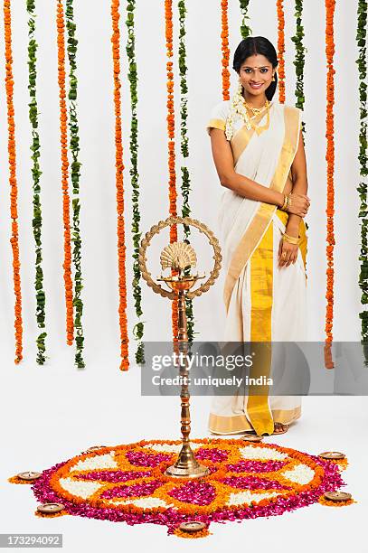 south indian woman standing near rangoli of flowers at onam - onam foto e immagini stock