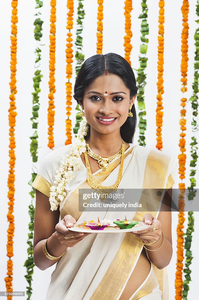 South Indian woman holding a puja thali at Onam