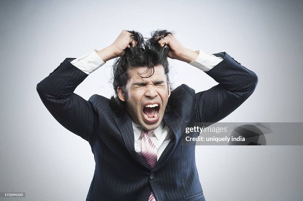 Businessman pulling his hair in frustration