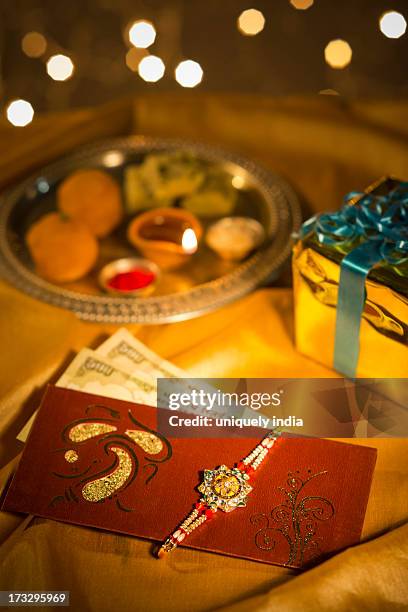 envelop of cash with a rakhi - akhi stock pictures, royalty-free photos & images