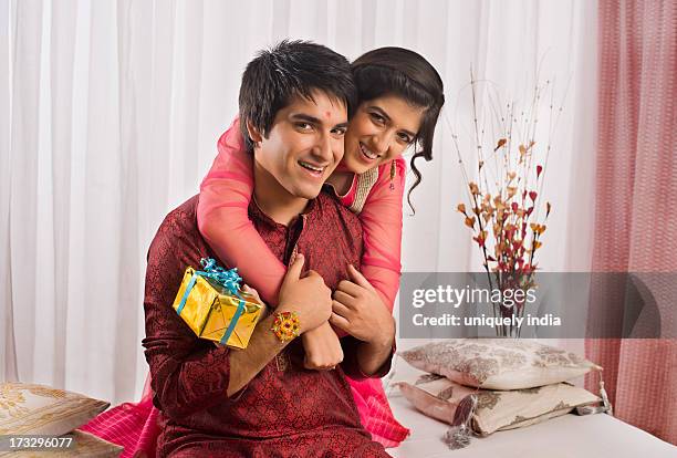 teenage girl hugging her brother at raksha bandhan - raksha bandhan stock pictures, royalty-free photos & images