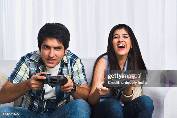 brother and sister playing video game - command sisters photos et images de collection
