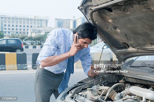 Businessman Using A Mobile Phone Near A Broken Down Car Gurgaon Haryana India, 照片檔