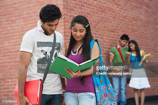 university students reading a book in university campus - delhi university stock pictures, royalty-free photos & images