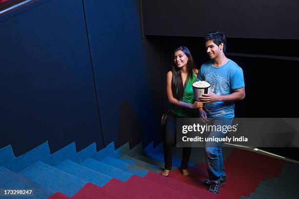 couple moving up on steps in a cinema hall - couple entering the theater stock pictures, royalty-free photos & images