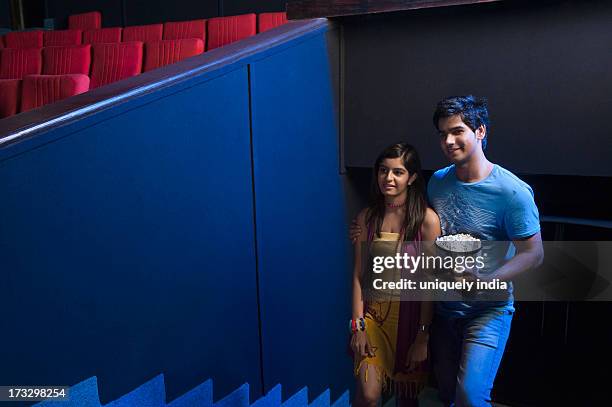 couple moving up on steps in a cinema hall - couple entering the theater stock pictures, royalty-free photos & images