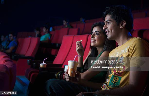 couple watching movie in a cinema hall - indian couple in theaters stock pictures, royalty-free photos & images