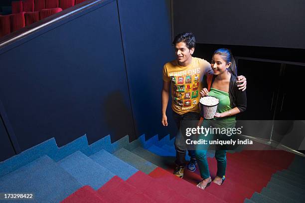 couple moving up on steps in a cinema hall - couple entering the theater stock pictures, royalty-free photos & images