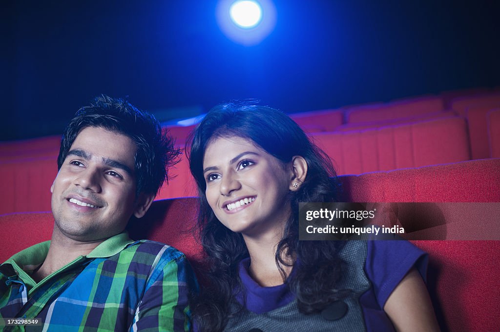 Couple enjoying movie in a cinema hall