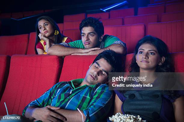 youngsters feeling bored while watching movie in a cinema hall - indian couple in theaters stock pictures, royalty-free photos & images