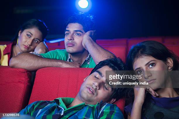 youngsters feeling bored while watching movie in a cinema hall - indian couple in theaters stock pictures, royalty-free photos & images