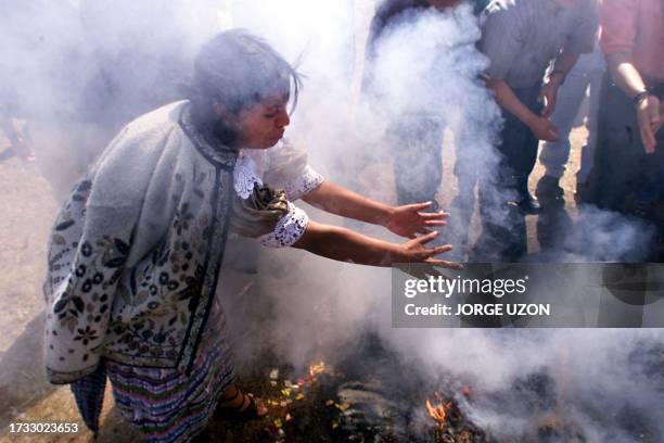 An elderly indian participated in a ritual during the Mayan Solar year 5115 in Guatemala City, 24 February, 2000. Una mujer indigena ora frente a una...