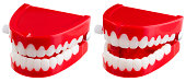 Two toy wind-up chatter teeth on a white background