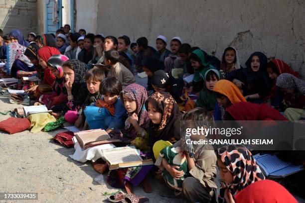 Afghan children study the Quran at an open air madrassa or an Islamic school on the outskirts of Kandahar province on October 19, 2023.
