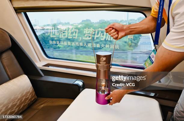 Flame guard displays the flame lantern on high-speed train at Guangzhou South Railway Station on October 12, 2023 in Guangzhou, Guangdong Province of...