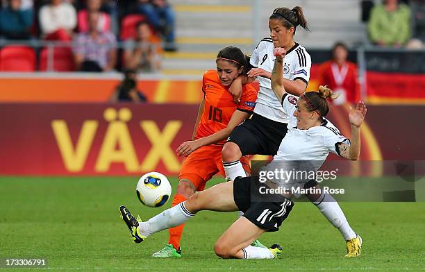 Lena Lotzen and Anja Mittag of Germany battle for the ball with Danielle van de Donk of Netherlands during the UEFA Women's Euro 2013 group B match...