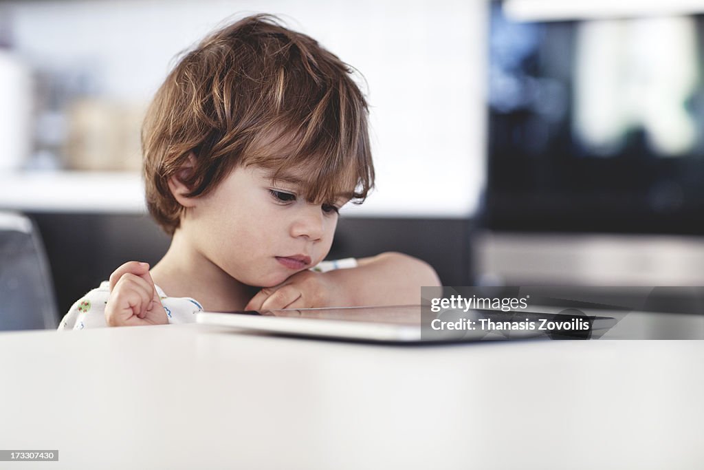 Portrait of a small boy looking a tablet