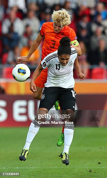 Celia Okoyino Da Mbabi of Germany heads for the ball with Daphne Koster of Netherlands during the UEFA Women's Euro 2013 group B match at Vaxjo Arena...