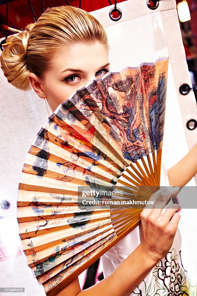 Girl looking over foldable fan