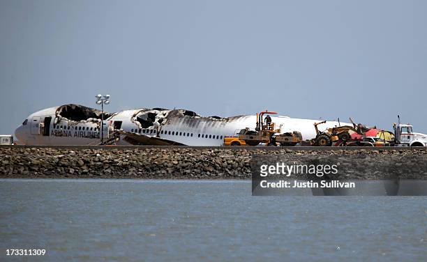 Heavy equipment sits next to the wreckage of Asiana Airlines flight 214 at San Francisco International Airport on July 11, 2013 in San Francisco,...