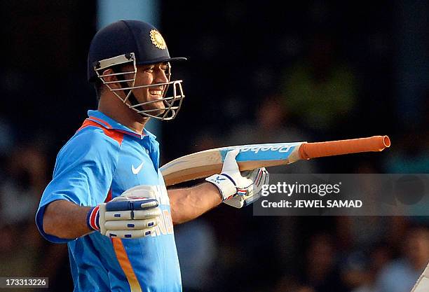 Indian cricket team captain Mahendra Sing Dhoni celebrates after hitting a boundary for six runs to seal their victory during the final match of the...