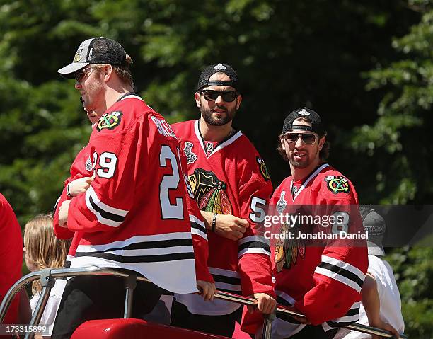 Bryan Bickell, Brandon Bollig and Nick Leddy look to fans during the Chicago Blackhawks Victory Parade and Rally on June 28, 2013 in Chicago,...