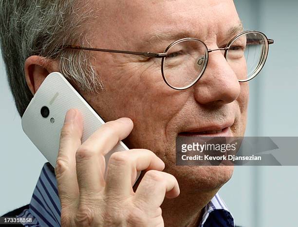 Eric Schmidt, executive chairman of Google, makes a call on the still to be released Google produced Moto X phone during the Allen & Co. Annual...