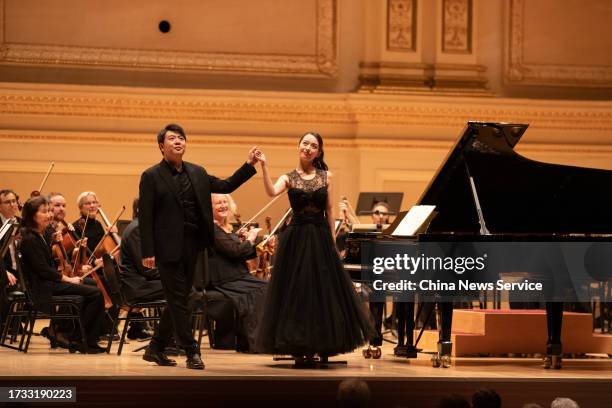 Pianist Lang Lang and his wife Gina Alice acknowledge the audience during a concert at Carnegie Hall on October 12, 2023 in New York City.