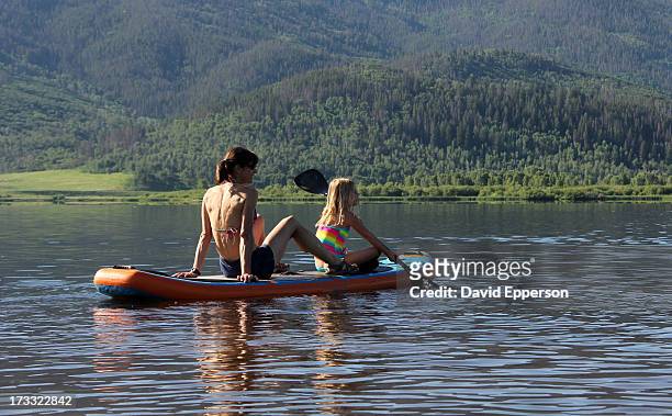 mother and daughter stand up paddle on alpine lake - steamboat springs stock pictures, royalty-free photos & images
