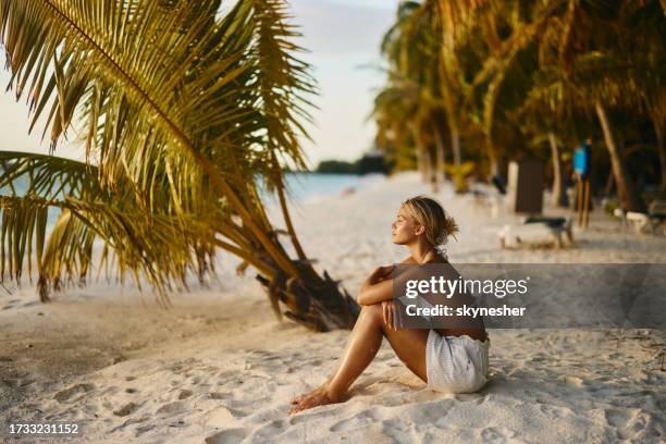 junge frau träumt während eines sommertages am strand. - malediven stock-fotos und bilder