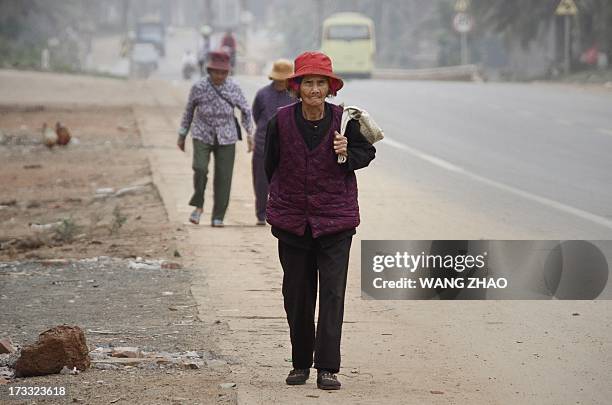 China-health-people-ageing-social,FEATURE BY TOM HANCOCK This picture taken on January 22, 2013 shows an elderly woman making her way along a road in...