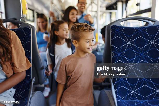 happy boy traveling with his family by a bus. - shuttle bus stock pictures, royalty-free photos & images